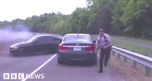 Officer inches from death as car spins across highway