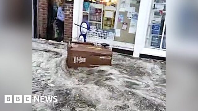 Shops flooded as torrent of water surges down street